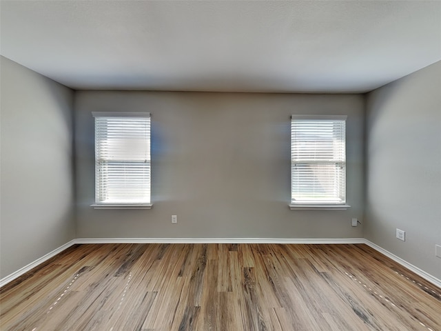 2002 Grimes Dr, Forney, TX 75126 - spare room featuring wood finished floors, baseboards, and plenty of natural light