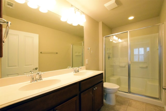 bathroom with tile patterned floors, toilet, a shower with shower door, and vanity