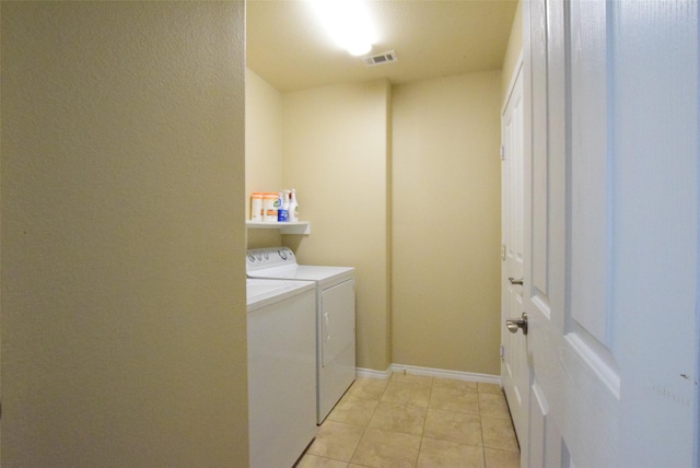 laundry room with separate washer and dryer and light tile patterned floors