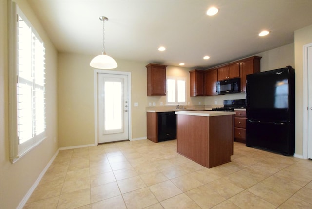 kitchen featuring a wealth of natural light, decorative light fixtures, a center island, and black appliances