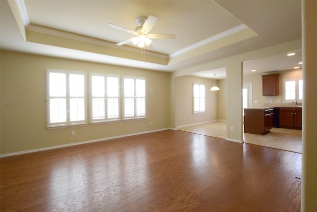 unfurnished living room with crown molding, a raised ceiling, and light hardwood / wood-style flooring