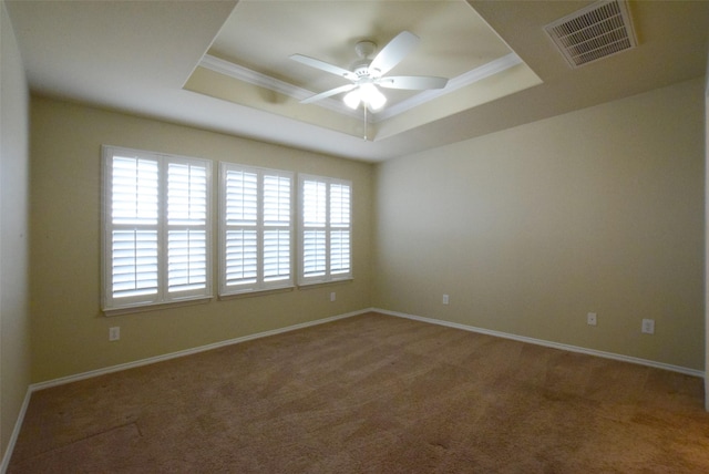 spare room with a raised ceiling, crown molding, carpet flooring, and ceiling fan