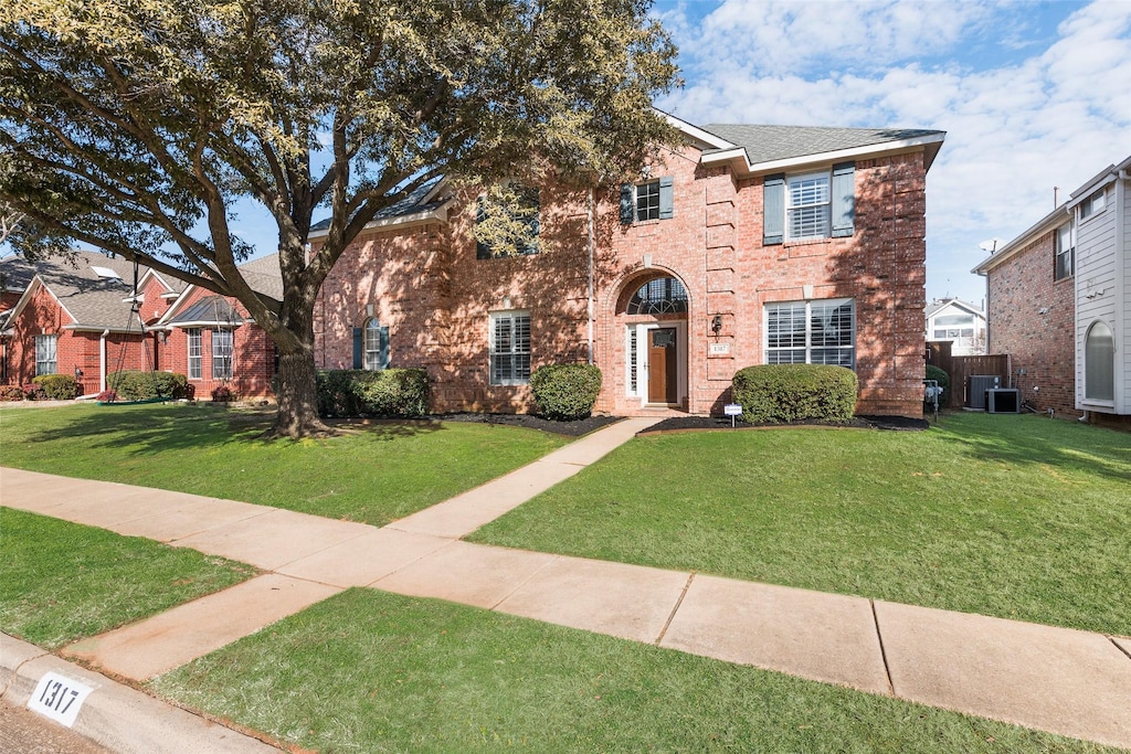 view of front of house featuring a front yard and central AC unit