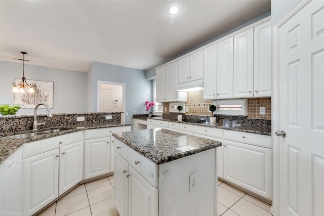 kitchen featuring light tile patterned flooring, sink, white cabinetry, hanging light fixtures, and a kitchen island