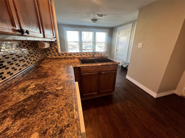 kitchen featuring tasteful backsplash, dark hardwood / wood-style flooring, sink, and a textured ceiling