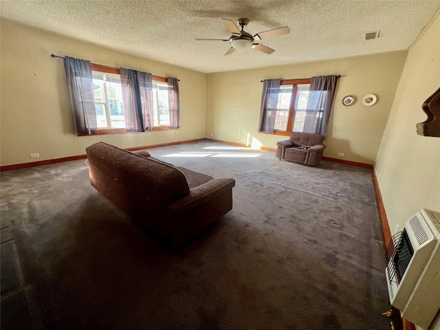 living room featuring heating unit, ceiling fan, a textured ceiling, and dark colored carpet