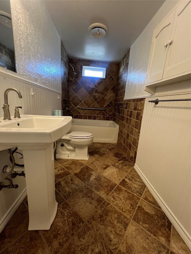 bathroom featuring toilet and tiled shower / bath combo