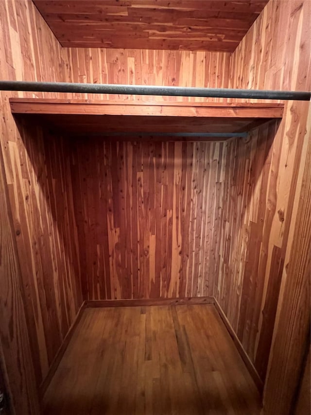 room details featuring wood ceiling, wooden walls, and hardwood / wood-style flooring