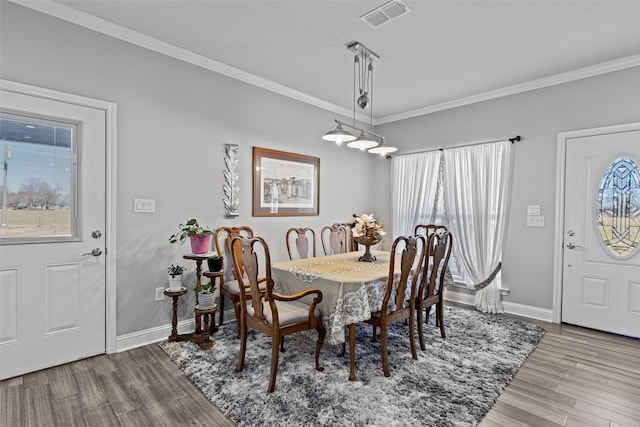 dining area featuring ornamental molding and light hardwood / wood-style floors