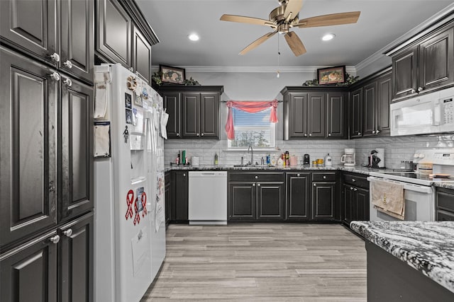 kitchen with sink, crown molding, light wood-type flooring, white appliances, and decorative backsplash