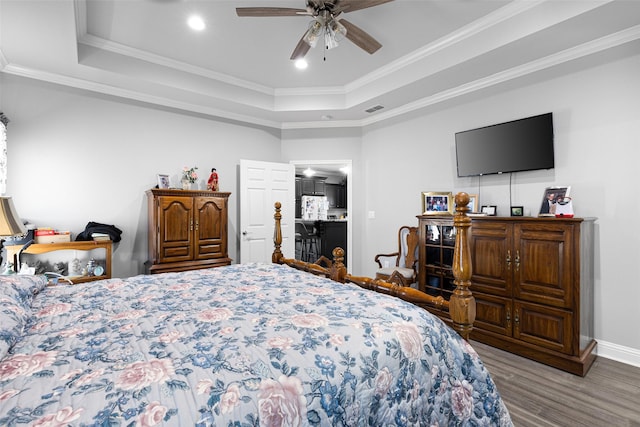 bedroom with a raised ceiling, crown molding, hardwood / wood-style floors, and ceiling fan