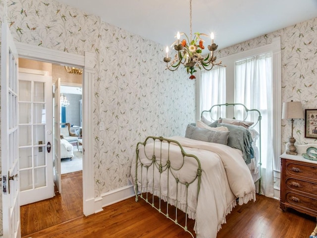 bedroom featuring an inviting chandelier and dark hardwood / wood-style flooring