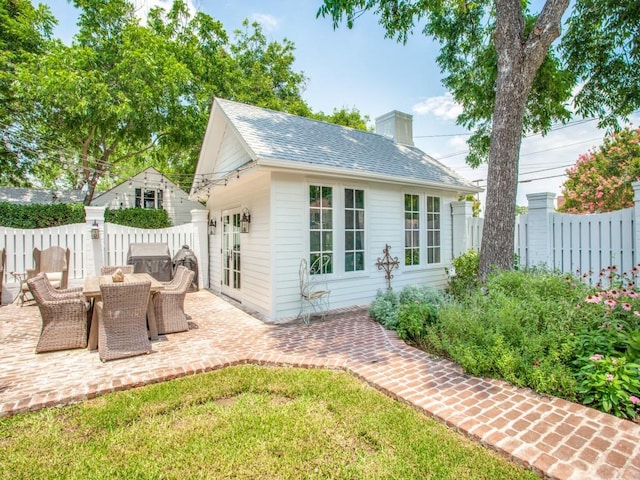 rear view of property with a yard and a patio area