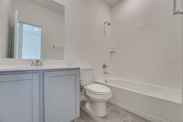 full bathroom featuring tile patterned flooring, tiled shower / bath, vanity, and toilet