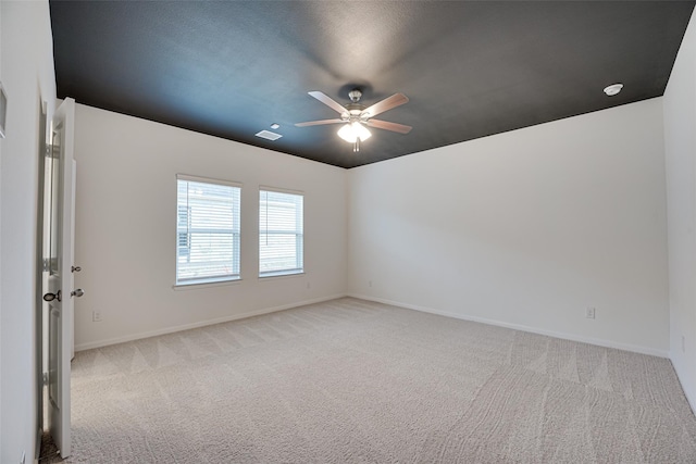 empty room with light carpet, a textured ceiling, and ceiling fan