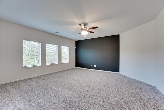 carpeted spare room with ceiling fan