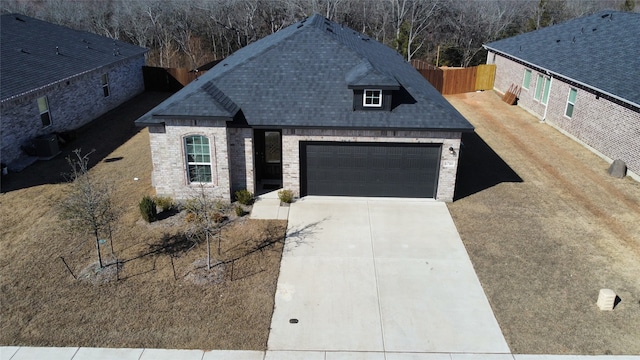 view of front of home with a garage and central air condition unit