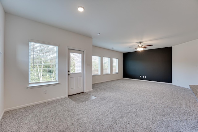 interior space with ceiling fan and light colored carpet