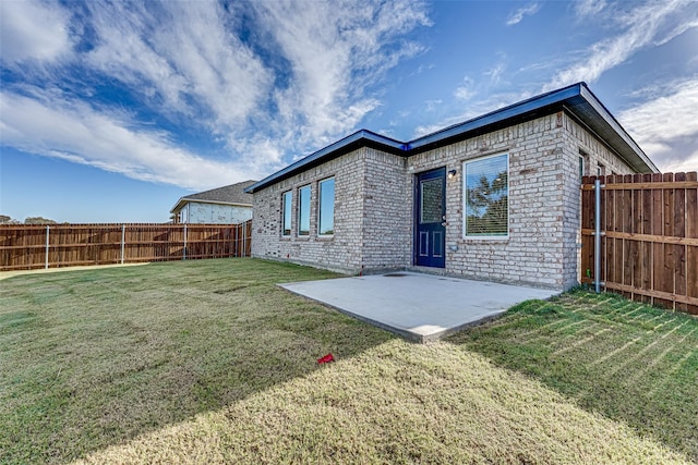 back of property featuring a yard and a patio area