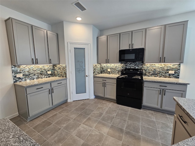 kitchen featuring gray cabinetry, light stone countertops, and black appliances