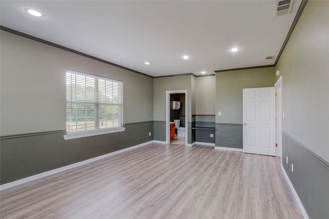 spare room with ornamental molding and light wood-type flooring