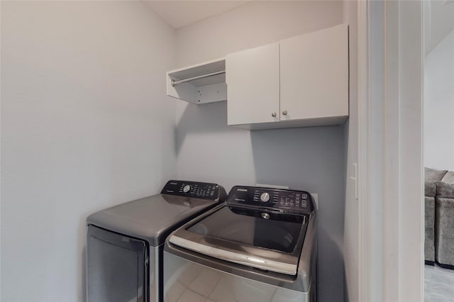 washroom with cabinets and washer and clothes dryer