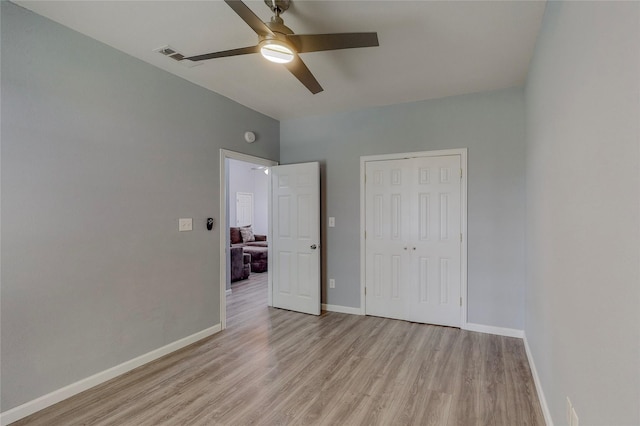 unfurnished bedroom featuring light hardwood / wood-style flooring, a closet, and ceiling fan