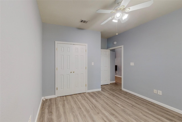 unfurnished bedroom with light hardwood / wood-style flooring, ceiling fan, and a closet