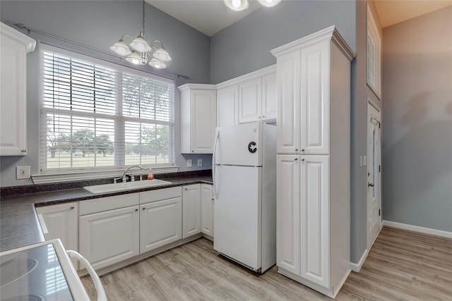 kitchen with sink, light hardwood / wood-style flooring, white cabinets, and white fridge