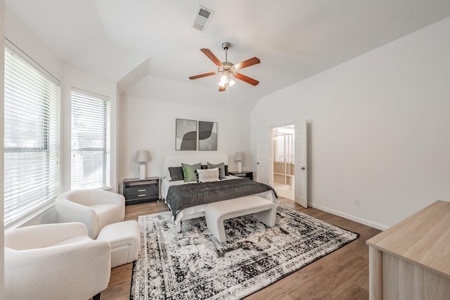 bedroom featuring hardwood / wood-style floors, lofted ceiling, connected bathroom, and ceiling fan