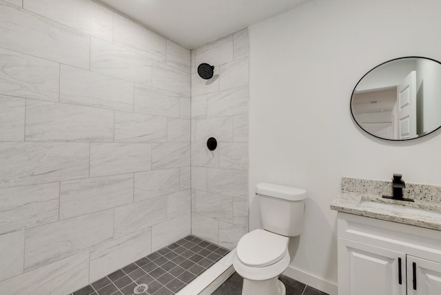 bathroom with vanity, tiled shower, tile patterned floors, and toilet