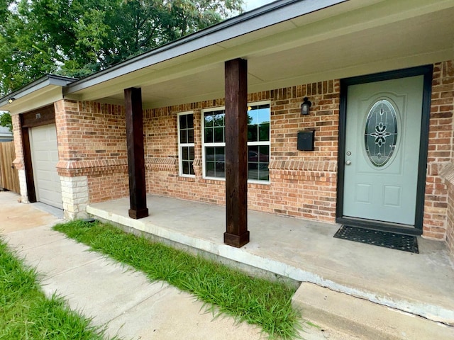 entrance to property featuring a garage and a porch