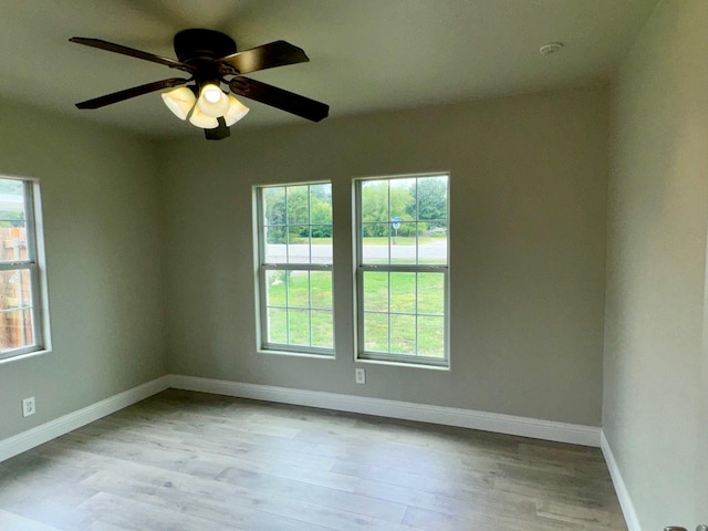 spare room with ceiling fan and light wood-type flooring