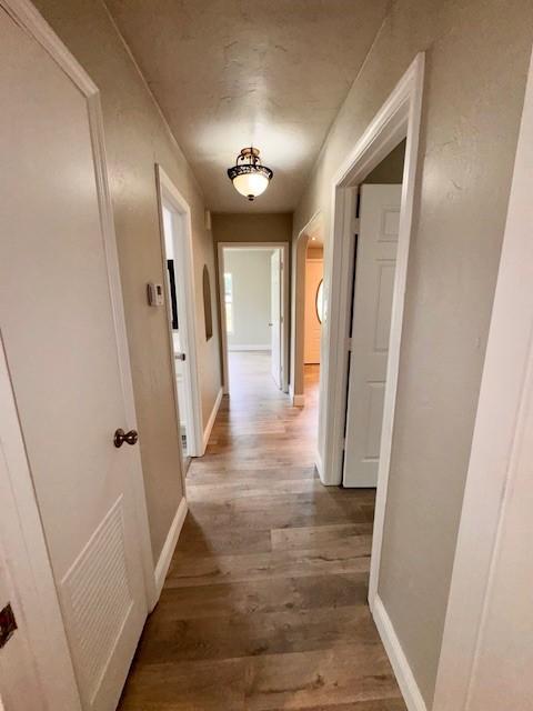 corridor with wood-type flooring