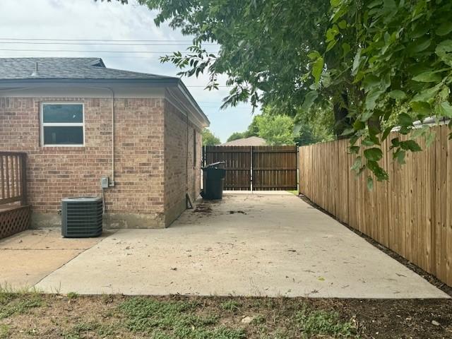 view of property exterior with central AC unit and a patio