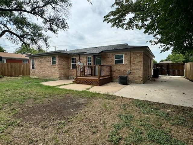 back of property with cooling unit, a yard, and a patio