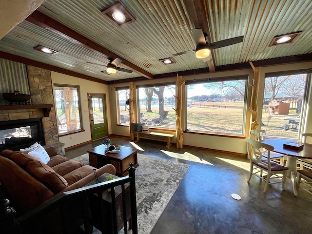 sunroom / solarium featuring plenty of natural light, wood ceiling, and a fireplace