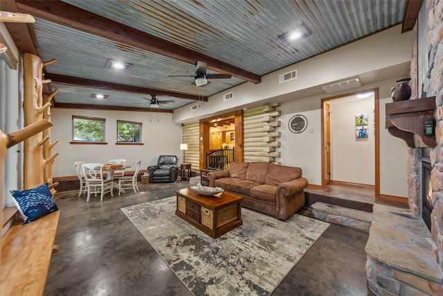 living room featuring wood ceiling, beam ceiling, a stone fireplace, and ceiling fan