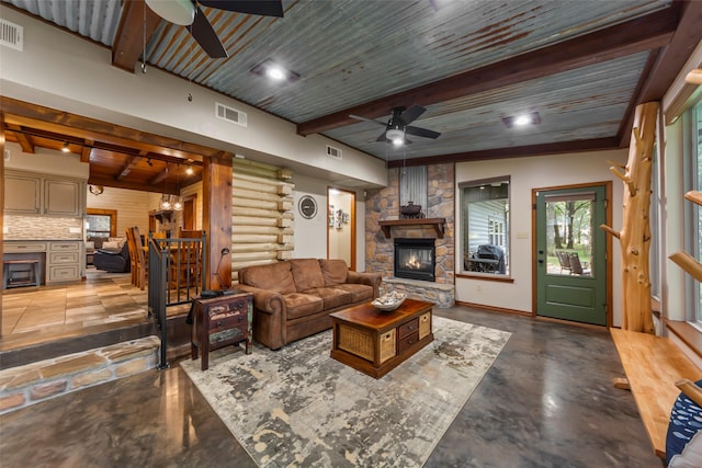 living room featuring beamed ceiling, a fireplace, wood ceiling, and concrete flooring