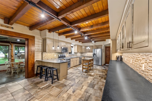 kitchen featuring a breakfast bar, a center island, hanging light fixtures, track lighting, and appliances with stainless steel finishes