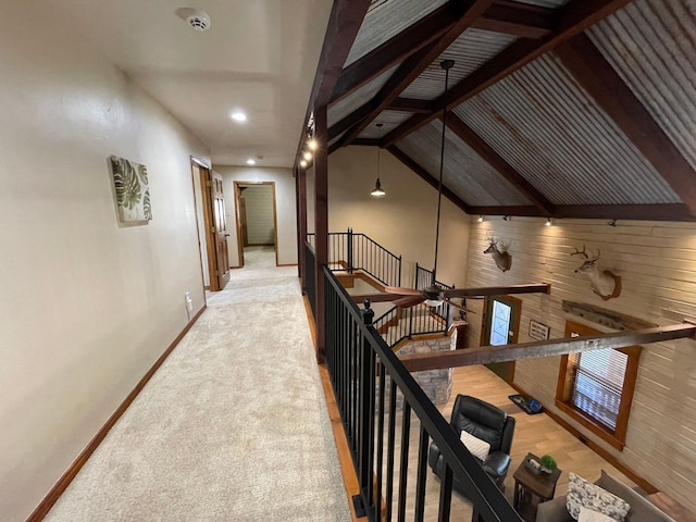 hall with light carpet and vaulted ceiling with beams