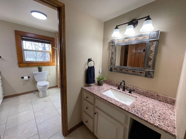 bathroom featuring tile patterned floors, vanity, and toilet