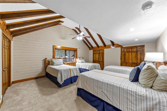 bedroom featuring ceiling fan, vaulted ceiling with beams, light colored carpet, and wooden walls