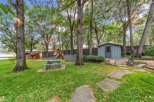 view of yard with a storage shed and a playground