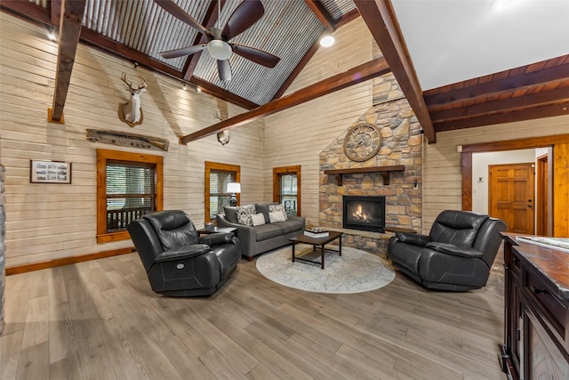 living room featuring beamed ceiling, wood walls, high vaulted ceiling, and light hardwood / wood-style flooring