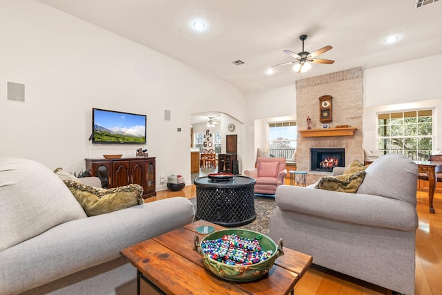 living room featuring a towering ceiling, plenty of natural light, and light hardwood / wood-style flooring