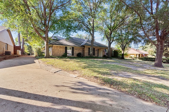 ranch-style home with a front yard and central AC unit