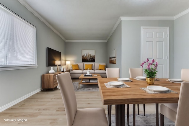 dining space with ornamental molding and light hardwood / wood-style flooring