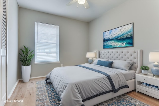 bedroom featuring a ceiling fan, light wood-style flooring, and baseboards