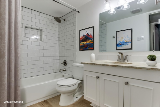 full bathroom featuring visible vents, toilet, shower / bath combo with shower curtain, vanity, and wood finished floors